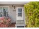 Inviting front entrance featuring gray siding, a storm door, and manicured bushes at 12780 E Bethany Pl, Aurora, CO 80014