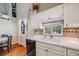 Well-lit kitchen with white cabinetry, tile backsplash, a large sink and modern appliances at 12780 E Bethany Pl, Aurora, CO 80014