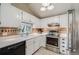 Well-equipped kitchen featuring modern appliances, tile backsplash, and white cabinets at 12780 E Bethany Pl, Aurora, CO 80014