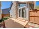 Back patio with sliding glass doors, stone fireplace feature, and privacy fence at 12780 E Bethany Pl, Aurora, CO 80014