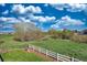 Expansive backyard with a large green space, mature trees, and white fencing, perfect for outdoor activities at 21229 E 50Th Ave, Denver, CO 80249