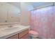 Bright bathroom with a pink floral shower curtain and white tiled countertop at 21229 E 50Th Ave, Denver, CO 80249