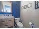 Cozy half-bathroom features modern fixtures, decor and a striking blue accent wall at 21229 E 50Th Ave, Denver, CO 80249