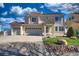 Stately two-story home with a three-car garage, manicured lawn, and stone landscape edging at 21229 E 50Th Ave, Denver, CO 80249