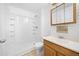Bright bathroom showcasing a shower-tub combo, oak vanity, and framed mirror at 4064 S Himalaya Way, Aurora, CO 80013