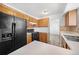 Kitchen with oak cabinets, black appliances, tile flooring and backsplash, and bright lighting, offering functionality and style at 4064 S Himalaya Way, Aurora, CO 80013