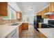 Well-lit kitchen featuring oak cabinets, tile backsplash, and neutral countertops with black appliances at 4064 S Himalaya Way, Aurora, CO 80013