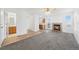 Bright living room features a brick fireplace, plush carpeting, and flows into the kitchen and bathroom at 4064 S Himalaya Way, Aurora, CO 80013