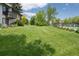 Expansive backyard with mature trees, open green space, and a community pool in the distance at 6505 Kalua Rd # 104B, Boulder, CO 80301