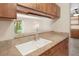 Kitchen featuring wood cabinets, laminate countertops, and a breakfast bar overlooking the living area at 6505 Kalua Rd # 104B, Boulder, CO 80301