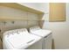 A dedicated laundry room featuring a washer, a dryer, and wall shelving at 6505 Kalua Rd # 104B, Boulder, CO 80301