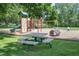 Community playground with slides, climbing structures, and picnic tables surrounded by mature trees at 6505 Kalua Rd # 104B, Boulder, CO 80301