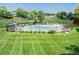 A fenced in swimming pool with lounge chairs and green grass around it, surrounded by trees at 6505 Kalua Rd # 104B, Boulder, CO 80301
