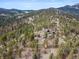 Aerial view showcases the lush greenery surrounding the beautiful mountain home at 13660 Rampart Dr, Conifer, CO 80433