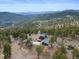 Expansive aerial view showcases the home nestled in the mountains with scenic views at 13660 Rampart Dr, Conifer, CO 80433
