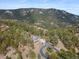 Aerial view showcases the home nestled in a densely wooded area at 13660 Rampart Dr, Conifer, CO 80433