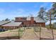 Backyard view with lush landscaping, garden beds, and a charming wooden fence, showcasing the private setting at 13660 Rampart Dr, Conifer, CO 80433