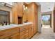 Bathroom with double sinks, tile floor, wood cabinets, and a scenic view at 13660 Rampart Dr, Conifer, CO 80433