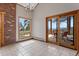 Dining room features tile floor, access to the deck with seating, and a brick accent wall at 13660 Rampart Dr, Conifer, CO 80433