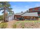 View of the property featuring outbuildings, garage, and lush green landscape, showcasing the wooded acreage at 13660 Rampart Dr, Conifer, CO 80433