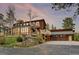 Stunning multi-level home with a two-car garage and beautiful wood siding, complemented by lush greenery at 13660 Rampart Dr, Conifer, CO 80433