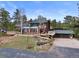 Spacious home with a wraparound deck, large windows, and lush landscaping with a charming stone creek at 13660 Rampart Dr, Conifer, CO 80433