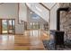 Open living room featuring a wood-burning fireplace, high ceilings, large windows and access to a deck at 13660 Rampart Dr, Conifer, CO 80433