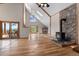 Spacious living room with vaulted ceilings, stone fireplace, and large windows offering scenic outdoor views at 13660 Rampart Dr, Conifer, CO 80433