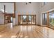 Bright living room with hardwood floors, high ceilings, and a sliding door to the deck offering scenic views at 13660 Rampart Dr, Conifer, CO 80433