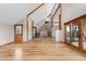Bright and airy living room featuring vaulted ceilings, hardwood floors, wood trim and a cozy wood burning fireplace at 13660 Rampart Dr, Conifer, CO 80433