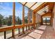 Light-filled sunroom with brick flooring and panoramic views of the surrounding landscape and plenty of natural light at 13660 Rampart Dr, Conifer, CO 80433