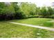 Lush green backyard with mature trees and a concrete walkway at 815 S Jersey St, Denver, CO 80224