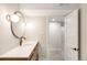 Stylish bathroom featuring a modern vanity, round mirror, and updated lighting fixtures at 815 S Jersey St, Denver, CO 80224