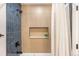Modern bathroom featuring stylish blue tiling, a shower with wood look niche, and contemporary fixtures at 815 S Jersey St, Denver, CO 80224