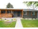 Charming home featuring a welcoming porch with wood accents, lush green lawn, and rock garden at 815 S Jersey St, Denver, CO 80224
