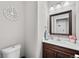 Charming powder room features a wood vanity, white sink, and decorative wall art at 12214 Stone Timber Ct, Parker, CO 80134