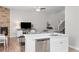 Bright open concept featuring island with sink and dishwasher, view into living room with fireplace at 12214 Stone Timber Ct, Parker, CO 80134