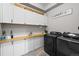 Well-organized laundry room features ample storage, counter space, and modern washer/dryer units at 12214 Stone Timber Ct, Parker, CO 80134