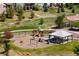 Community playground with swings, slide, climbing structure, and covered picnic area, surrounded by lush landscaping and grassy areas at 12214 Stone Timber Ct, Parker, CO 80134
