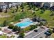 Aerial view of pool area with lounge chairs and tables near a parking lot and grassy hill at 12214 Stone Timber Ct, Parker, CO 80134