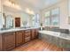 Bright bathroom featuring double sinks, a soaking tub, and updated fixtures at 10050 Eagle Valley Way, Highlands Ranch, CO 80129