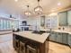 Stylish kitchen featuring an island with seating, modern appliances, and open access to a living area at 10050 Eagle Valley Way, Highlands Ranch, CO 80129