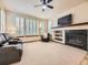 Cozy living room with a fireplace, mounted TV, and large windows with shutters at 10050 Eagle Valley Way, Highlands Ranch, CO 80129
