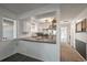 Modern kitchen with white cabinets and granite countertops, open to dining area at 8845 S Brentwood St, Littleton, CO 80128