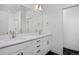Bathroom featuring double sinks, stone countertops, white cabinets, and black and white tile floors at 10860 Lyric St, Lone Tree, CO 80134