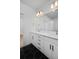 Bright bathroom with double sinks, white cabinets, stone countertops and black and white tile floors at 10860 Lyric St, Lone Tree, CO 80134