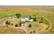 Drone shot of the property featuring the house, barn, and tennis court against a scenic backdrop at 11881 County Road 37, Fort Lupton, CO 80621