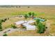 Panoramic view of the property showcasing the house, tennis court, and surrounding landscape at 11881 County Road 37, Fort Lupton, CO 80621