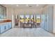 Bright dining area features a table and chairs, light wood floors, blue cabinetry, and access to an outdoor patio at 11881 County Road 37, Fort Lupton, CO 80621