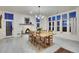 Elegant dining room featuring a fireplace, chandelier, and expansive windows with natural light at 11881 County Road 37, Fort Lupton, CO 80621